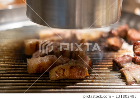 Samgyupsal, a popular Korean dish consisting of thick, sliced pork belly cooked on the grill Samgyupsal, a popular Korean dish consisting of thick, sliced pork belly cooked on the grill 131802495