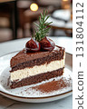 Decadent dessert cake slice with chocolate and cream on a white plate in an elegant cafe setting 131804112