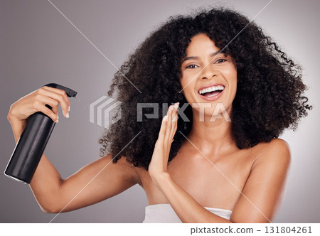 Portrait of black woman spray on hair for wellness, growth and natural shine on gray background. Beauty, salon and happy face of girl smile with hairspray, cosmetic products and keratin treatment Portrait of black woman spray on hair for wellness, growth and natural shine on gray background. Beauty, salon and happy face of girl smile with hairspray, cosmetic products and keratin treatment 131804261