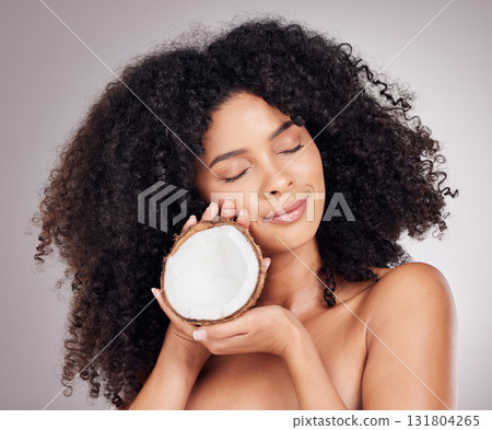 Coconut, beauty and black woman isolated on studio background for natural skincare, face and hair dream. Afro model or young person sleeping with fruit product or healthy oil benefits for dermatology Coconut, beauty and black woman isolated on studio background for natural skincare, face and hair dream. Afro model or young person sleeping with fruit product or healthy oil benefits for dermatology 131804265