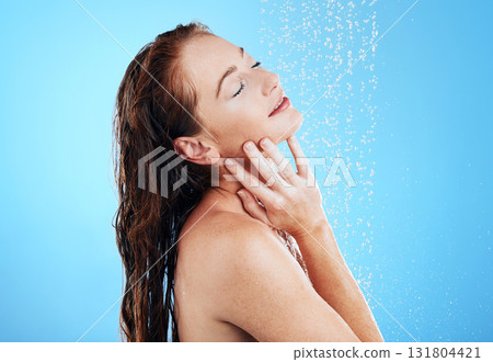 Shower, water and woman in studio, blue background and cleaning for hygiene, wellness and aesthetic health. Happy female model washing with wet drops for beauty, skincare and grooming for self care Shower, water and woman in studio, blue background and cleaning for hygiene, wellness and aesthetic health. Happy female model washing with wet drops for beauty, skincare and grooming for self care 131804421