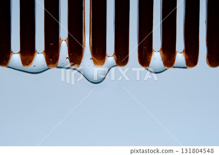 A comb with hair serum. The photo shows the texture of the cosmetic product. A comb with hair serum. The photo shows the texture of the cosmetic product. 131804548