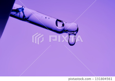 The texture of a cosmetic product with peptides in a pipette on a purple background. 131804561