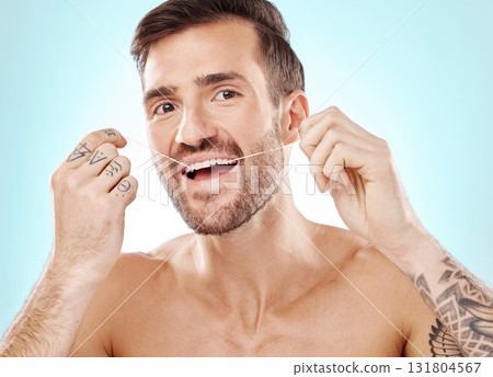 Portrait, face and man with dental floss in studio isolated on a blue background. Oral wellness, hygiene and happy male model flossing teeth for healthy mouth, cleaning or fresh breath and gum care. Portrait, face and man with dental floss in studio isolated on a blue background. Oral wellness, hygiene and happy male model flossing teeth for healthy mouth, cleaning or fresh breath and gum care. 131804567
