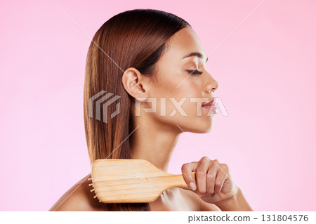 Woman, brushing hair and hairbrush beauty profile in studio for salon or hairdresser shine shampoo. Haircare of a aesthetic model on a pink background for color, glow or growth cosmetics and grooming 131804576