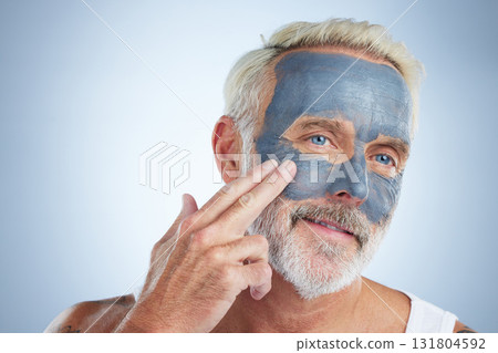 Elderly man, skin and face mask in studio for health, wellness and organic cleaning with smile by background. Senior model, hand or natural charcoal product for facial cosmetics for dermatology detox 131804592