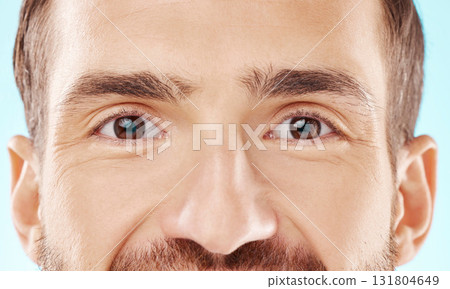 Skincare, vision and zoom on man eyes, beauty and grooming portrait isolated on blue background. Eye care, health and facial wellness, good eyesight and glowing skin on happy male model in studio. 131804649