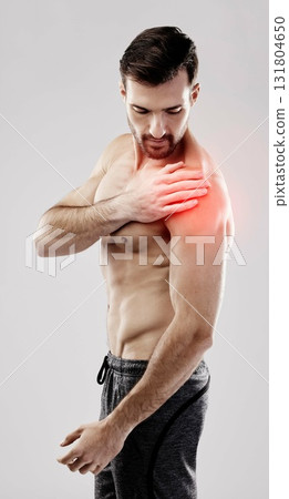 Injury, feeling and a man with arm pain and muscle sprain isolated on a grey studio background. Emergency, broken bone and person touching a painful, swollen and hurt area in the body on a backdrop 131804650