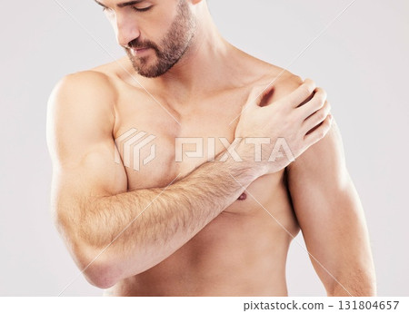 Injury, feeling and man with arm pain after sports isolated on a grey studio background. Fitness, accident and person touching a shoulder with a broken bone, body strain and problem after workout 131804657
