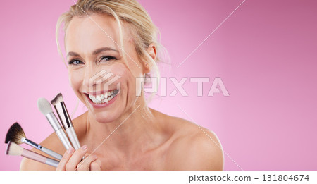 Portrait, makeup brush or mockup with a mature woman in studio on a pink background to promote a cosmetic product. Face, happy or cosmetics with an attractive older female posing for beauty treatment 131804674