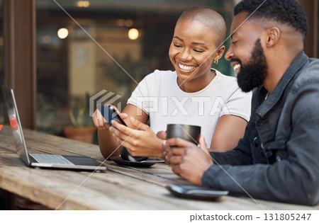 Cafe, social media and dating with a black couple laughing together at a table in a restaurant. Humor, love or date with a man and woman looking at a meme on a phone while bonding in a coffee shop 131805247