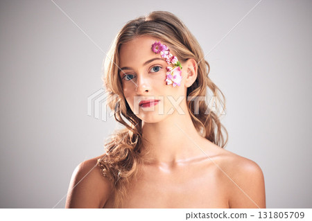 Flowers, beauty and portrait of woman for cosmetic wellness, skincare and natural makeup. Spring, art and girl with petal on face for spa aesthetic, luxury facial and cosmetology on studio background Flowers, beauty and portrait of woman for cosmetic wellness, skincare and natural makeup. Spring, art and girl with petal on face for spa aesthetic, luxury facial and cosmetology on studio background 131805709
