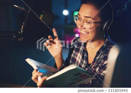 Radio dj, presenter and woman in a sound production studio reading a book with happiness. Headphones, recording and working female employee with discussion on air for web podcast and books talk 131805945