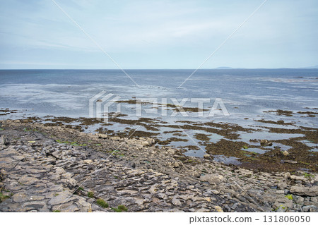 A beautiful view of the Irish coast, featuring the ocean, rocks, and a cloudy sky. A beautiful view of the Irish coast, featuring the ocean, rocks, and a cloudy sky. 131806050