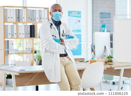 Covid, portrait and a doctor black man in his office, standing arms crossed for healthcare or insurance. Medical, mask and trust with a male medicine professional at work in a wellness clinic Covid, portrait and a doctor black man in his office, standing arms crossed for healthcare or insurance. Medical, mask and trust with a male medicine professional at work in a wellness clinic 131806220