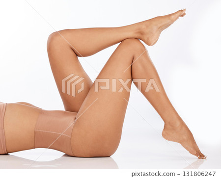 Legs, feet and beauty, black woman with epilation and skincare, laser hair removal with waxing on studio background. Cosmetics, healthy skin and glow, pedicure and spa treatment with body care 131806247