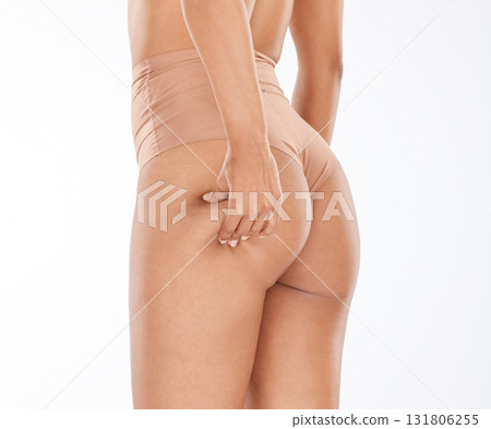 Hand, pinch and bum with a model black woman in studio isolated on a white background for natural cellulite. Skincare, buttocks and body positivity with a female pinching her real stretch marks Hand, pinch and bum with a model black woman in studio isolated on a white background for natural cellulite. Skincare, buttocks and body positivity with a female pinching her real stretch marks 131806255