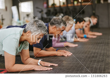 People, fitness and plank in class at gym for workout, core exercise or training together indoors. Diverse group or team in warm up ab muscle session for sport, health or wellness on gymnasium floor 131806263