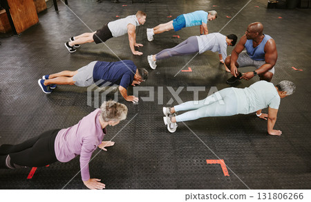 People, fitness and stretching in class with personal trainer at gym for workout, exercise or training. Diverse group in warm up plank session with coach for healthy exercising or strong core muscles 131806266