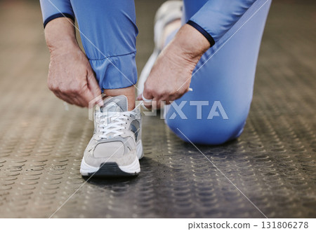 Hands, sports and tie shoes in gym to start workout, training or exercise for wellness. Fitness, athlete health or senior woman tying sneakers or footwear laces to get ready for exercising or running 131806278
