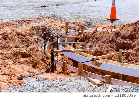 Wooden forms are set in place at construction site during curbed is concrete installation to sidewalk 131806389