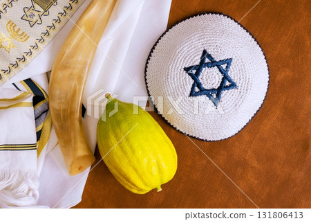 Traditional Jewish holiday etrog fruit with religious books. Sukkot celebration symbols Traditional Jewish holiday etrog fruit with religious books. Sukkot celebration symbols 131806413