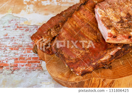 Savory smoked ribs are presented delectable meal on wooden board against textured backdrop Savory smoked ribs are presented delectable meal on wooden board against textured backdrop 131806425