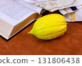 Yellow etrog citron fruit on open Hebrew prayer book Torah text during Jewish holiday of Sukkot against traditional religious text. Tanakh prayer holy book 131806438
