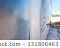 Spray painting is taking place at construction site as workers apply paint 131806463