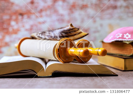 Religious Torah scroll lies on an open Holy book among artifacts in cozy, during Jewish festival Rosh Hashanah Religious Torah scroll lies on an open Holy book among artifacts in cozy, during Jewish festival Rosh Hashanah 131806477