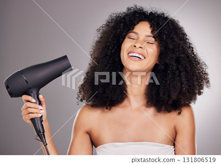 Face, beauty and black woman with hair dryer in studio isolated on gray background. Haircare, aesthetic or happy female model with machine to dry hairstyle after salon treatment for growth or texture 131806519