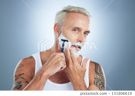 Senior man, razor and shaving beard with cream for grooming, skincare or hair removal against a studio background. Portrait of mature male with shaver, creme or foam for hygiene or facial treatment 131806619