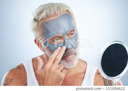 Man, mirror and clay mask for face skincare, wellness and organic cleaning with smile by studio background. Elderly male, hand and natural charcoal product for facial cosmetics for dermatology detox 131806622