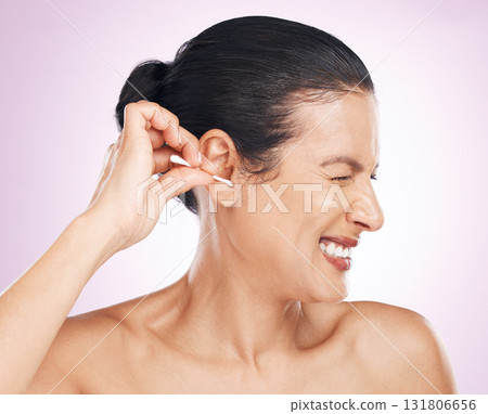 Woman, cotton bud and ear in studio for cleaning, struggle or pain for wellness by pink background. Model hand, self care or clean for hygiene, ears or natural product for healthy hearing by backdrop Woman, cotton bud and ear in studio for cleaning, struggle or pain for wellness by pink background. Model hand, self care or clean for hygiene, ears or natural product for healthy hearing by backdrop 131806656