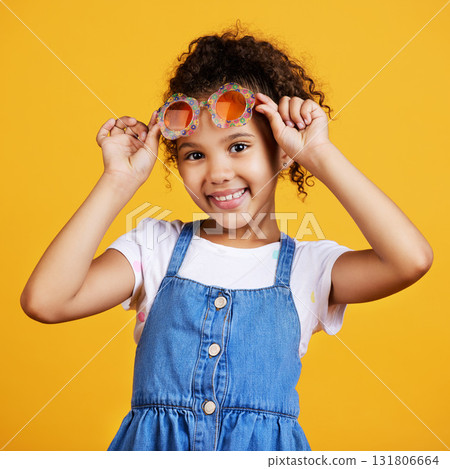 Girl child, studio portrait and sunglasses with smile, happiness and summer style by yellow background. Mixed race model, female kid and fashion frame on face with kids clothes, aesthetic and youth 131806664