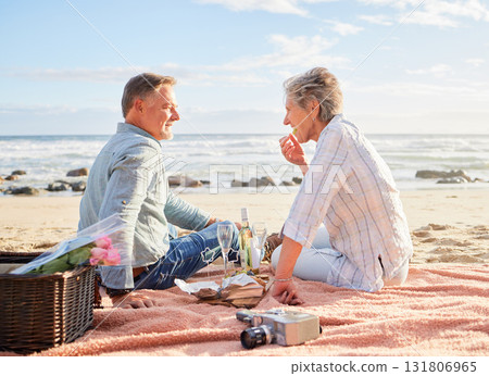 Senior couple, beach and picnic on blanket for romantic getaway, travel or valentines day celebration in nature. Happy elderly man and woman relax by a sandy ocean coast for date, basket meal or trip Senior couple, beach and picnic on blanket for romantic getaway, travel or valentines day celebration in nature. Happy elderly man and woman relax by a sandy ocean coast for date, basket meal or trip 131806965