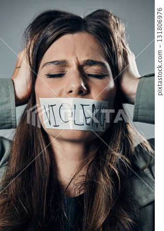 Woman, protest and tape on mouth in fear for cold war, armageddon or doomsday against a gray studio background. Female activist face with hands on head and message to stop or end global violence 131806976