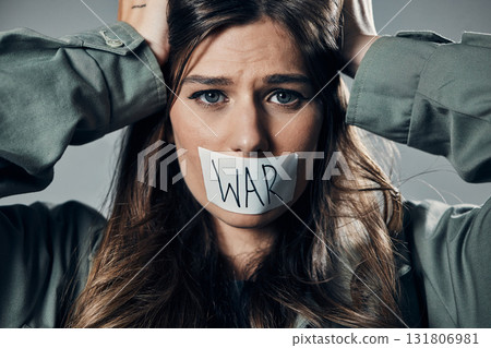 Woman, face and protest with tape on mouth in fear for cold war, armageddon or doomsday against gray studio background. Female activist with voice message to stop or end global violence in society Woman, face and protest with tape on mouth in fear for cold war, armageddon or doomsday against gray studio background. Female activist with voice message to stop or end global violence in society 131806981