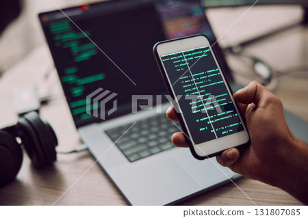 Coding, laptop and phone in hand with man, programmer and software update, information technology and code. Cybersecurity, ux and network with wifi, web design and cyber space with cpu programming 131807085
