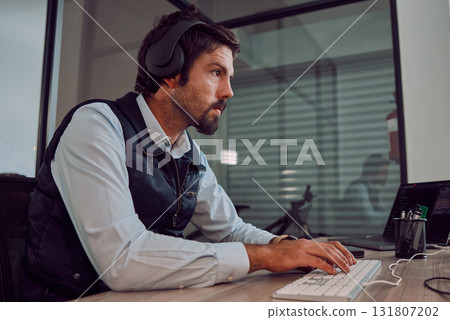Headphones, programmer keyboard and man typing, coding or programming online at night. Information technology, computer and male employee or coder working on software while streaming music or radio. Headphones, programmer keyboard and man typing, coding or programming online at night. Information technology, computer and male employee or coder working on software while streaming music or radio. 131807202