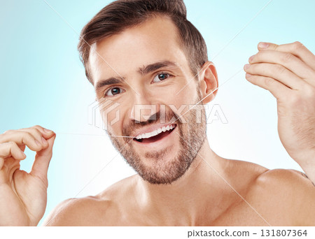 Face, portrait and man with dental floss in studio isolated on a blue background. Oral health, hygiene or happy male model flossing teeth for wellness, cleaning or fresh breath, cosmetics or gum care Face, portrait and man with dental floss in studio isolated on a blue background. Oral health, hygiene or happy male model flossing teeth for wellness, cleaning or fresh breath, cosmetics or gum care 131807364