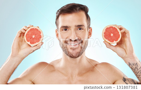 Man, skincare and studio portrait with grapefruit for health, nutrition and cosmetic wellness by blue background. Young model, fruit and vitamin c for natural detox, facial skin glow and aesthetic 131807381