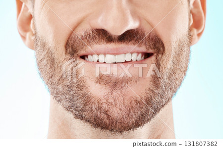 Teeth, smile and mouth of a man for dental care isolated on a blue background in a studio. Beard, happy and model showing results from whitening of tooth and promotion of an oral hygiene treatment 131807382