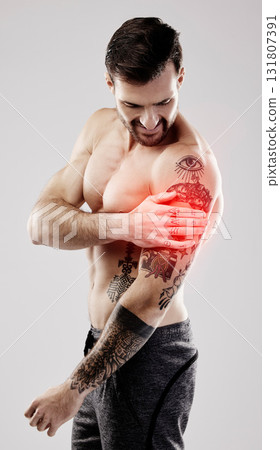Injury, inflammation and a man with arm pain and muscle sprain isolated on a grey background. Emergency, broken bone and person touching a painful, broken and hurt area in the body on a backdrop Injury, inflammation and a man with arm pain and muscle sprain isolated on a grey background. Emergency, broken bone and person touching a painful, broken and hurt area in the body on a backdrop 131807391
