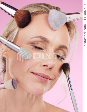Makeup, glam and face of a woman with brushes isolated on a pink background in a studio. Beauty, foundation and mature model with cosmetics from a beautician for a glamour look on a backdrop Makeup, glam and face of a woman with brushes isolated on a pink background in a studio. Beauty, foundation and mature model with cosmetics from a beautician for a glamour look on a backdrop 131807404