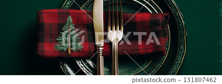 Dinner Setting With Plaid Napkin and Silverware on Dark Plate 131807462