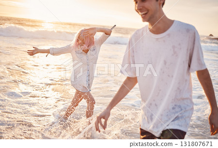 Couple at beach, splash in water with ocean, travel and freedom outdoor, love and care in relationship with youth. Cafe free at sunset, nature and sea waves with young people on holiday in Hawaii Couple at beach, splash in water with ocean, travel and freedom outdoor, love and care in relationship with youth. Cafe free at sunset, nature and sea waves with young people on holiday in Hawaii 131807671