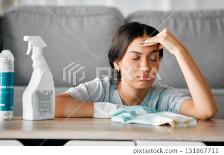 Headache, cleaning stress and tired black woman cleaner feeling burnout from housekeeping. Home, dust cloth and fatigue of house worker with hygiene products for furniture in a living room lounge 131807711