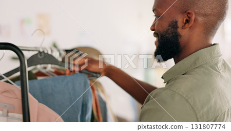 Man designer, entrepreneur startup and clothes shopping rack in boutique and design studio. Happy worker, creative job and wardrobe of clothing, fashion and professional working in retail store Man designer, entrepreneur startup and clothes shopping rack in boutique and design studio. Happy worker, creative job and wardrobe of clothing, fashion and professional working in retail store 131807774