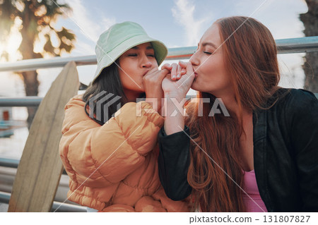 Playful, kiss and friends with a hand promise, support and secret in the city of California. Happy, together and women with affection, outdoor conversation and playing with happiness as besties 131807827